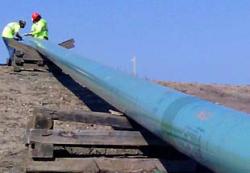 Pipeline workers work on a section of pipe above ground